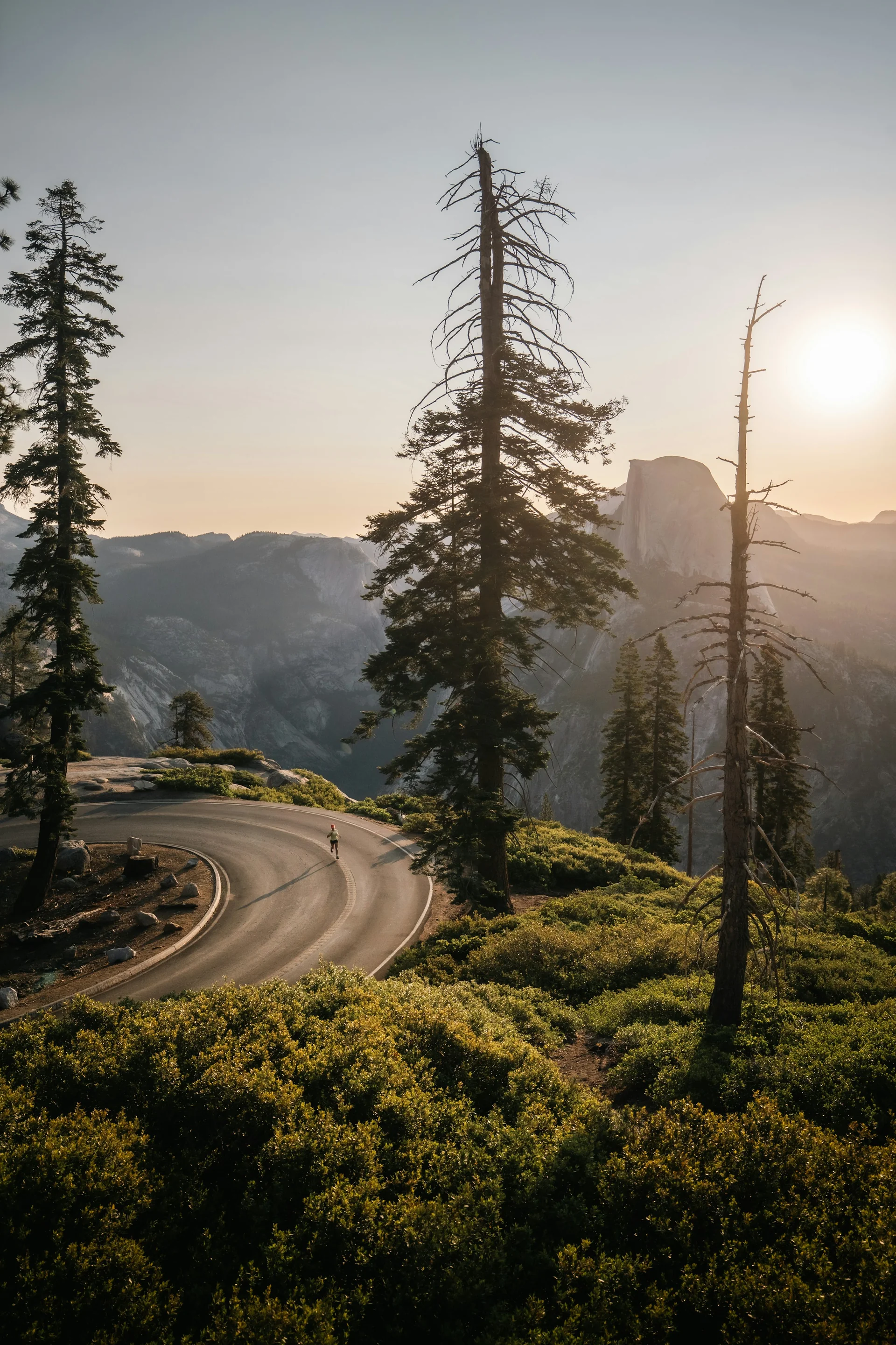 A winding mountain road at sunset, photographed by Venti Views. An illustrative setting, not a documented camera location.
